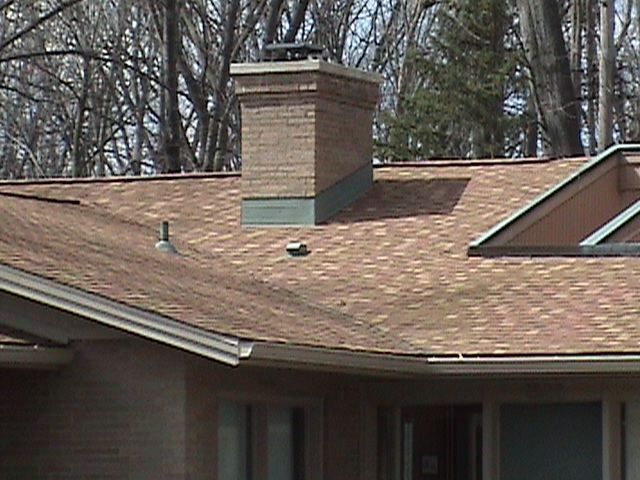 Detail of the flashing around the chimney on this homes shingled roof replacement.