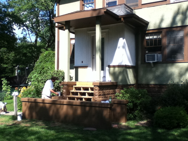 Vertical wood siding installed and primed. Concrete wall and cap painted.