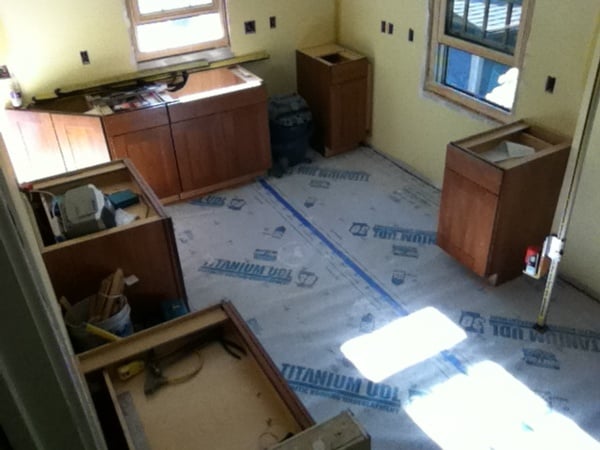 Kitchen base cabinets installed, flooring installed and protected during construction.